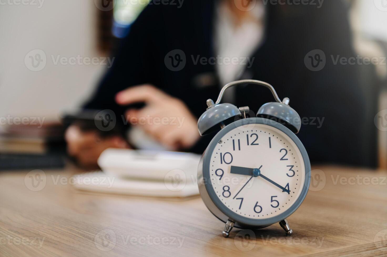 Alarm clock on the desk. Business working in modern office building or home at night using laptop. photo