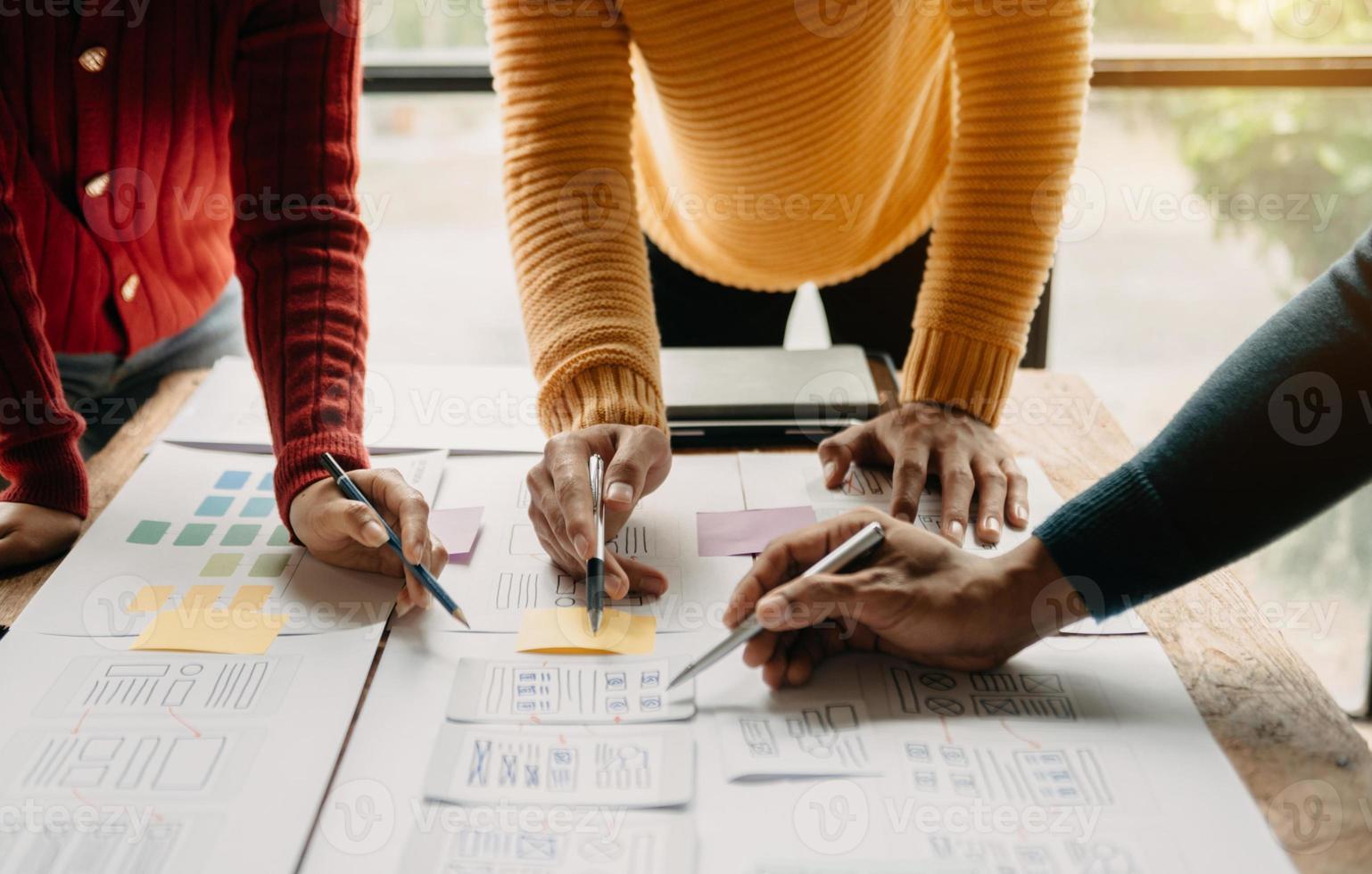 UX developer and ui designer brainstorming about mobile app interface wireframe design with customer breif and color code at modern office. photo