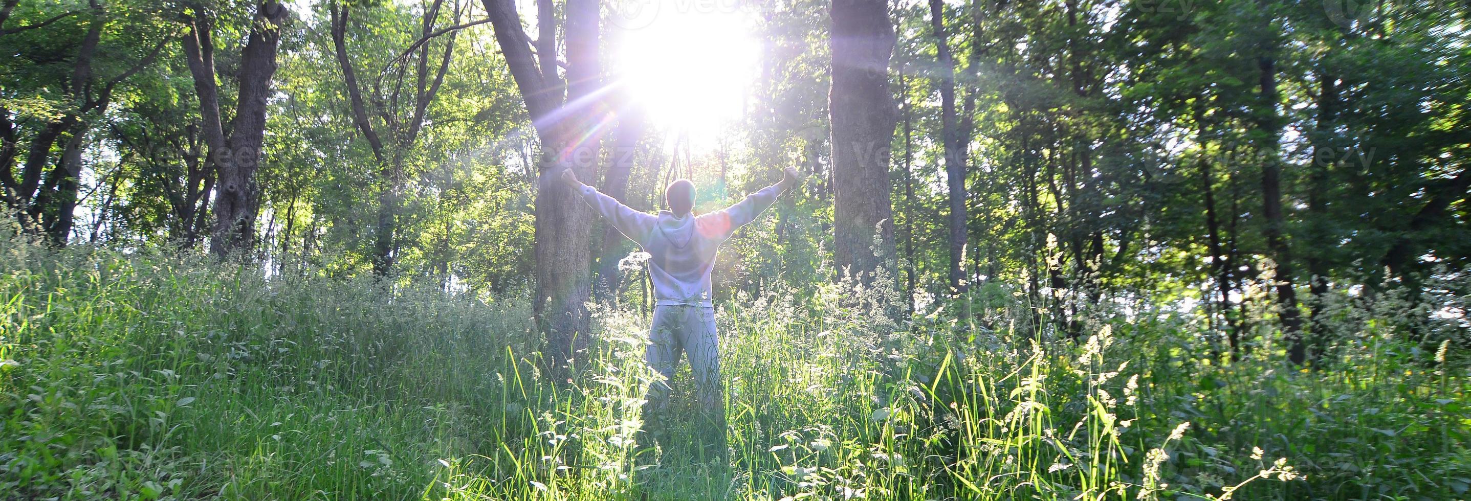 A young guy in a gray sports suit rejoices in the rising of the photo