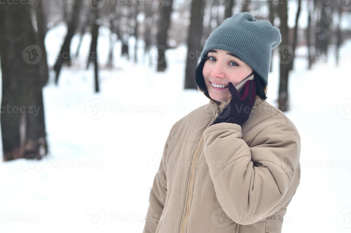 retrato de invierno de niña con teléfono inteligente foto