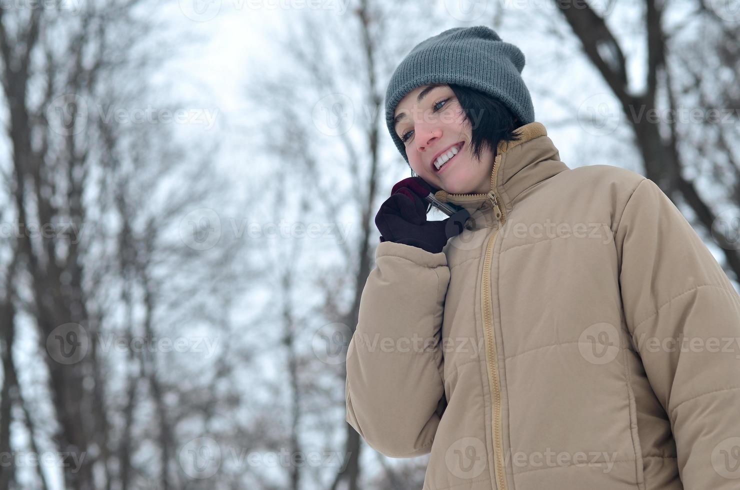 Winter portrait of young girl with smartphone photo