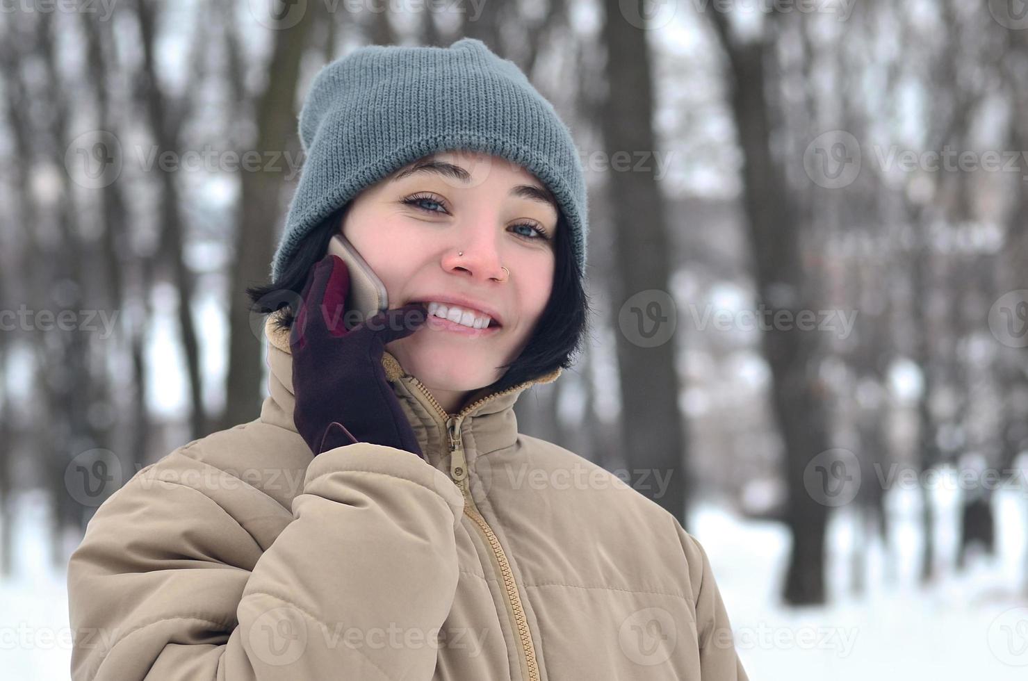 Winter portrait of young girl with smartphone photo