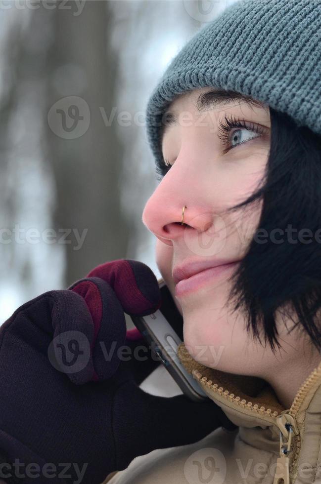 retrato de invierno de niña con teléfono inteligente foto