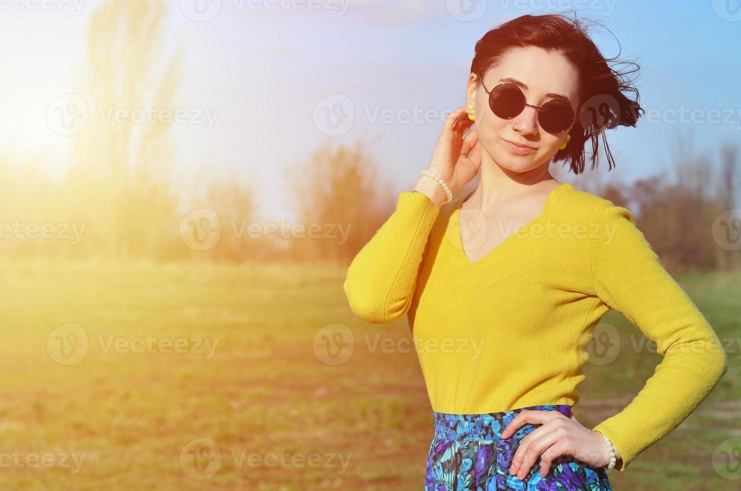 Attractive and cute Brunette girl in a yellow sweater walks thro photo