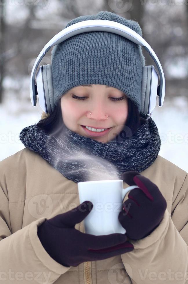 Young girl with headphones and coffee cup photo