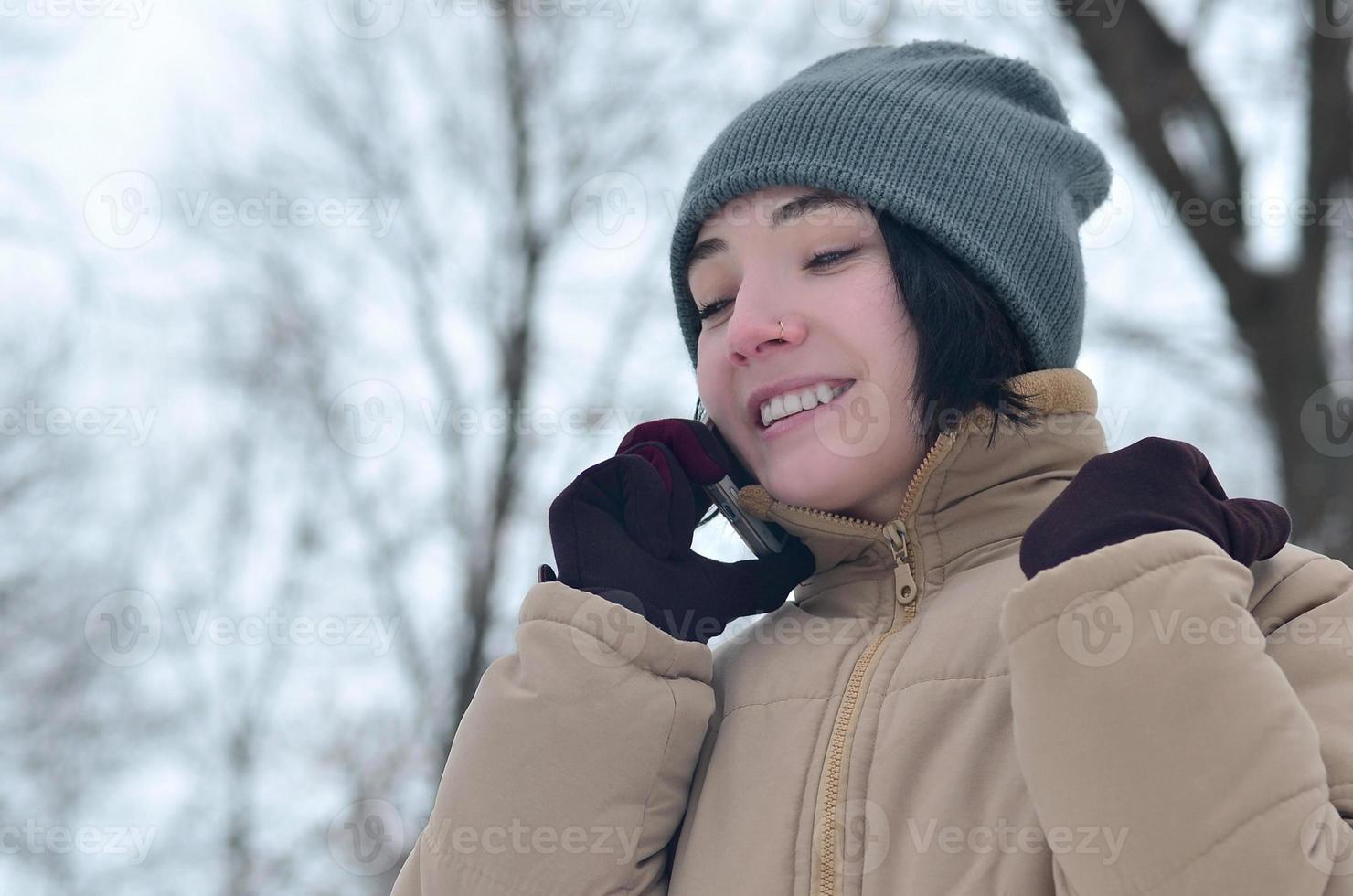 Winter portrait of young girl with smartphone photo