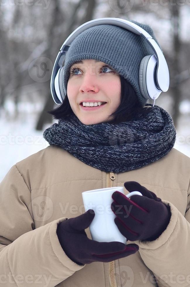 Young girl with headphones and coffee cup photo