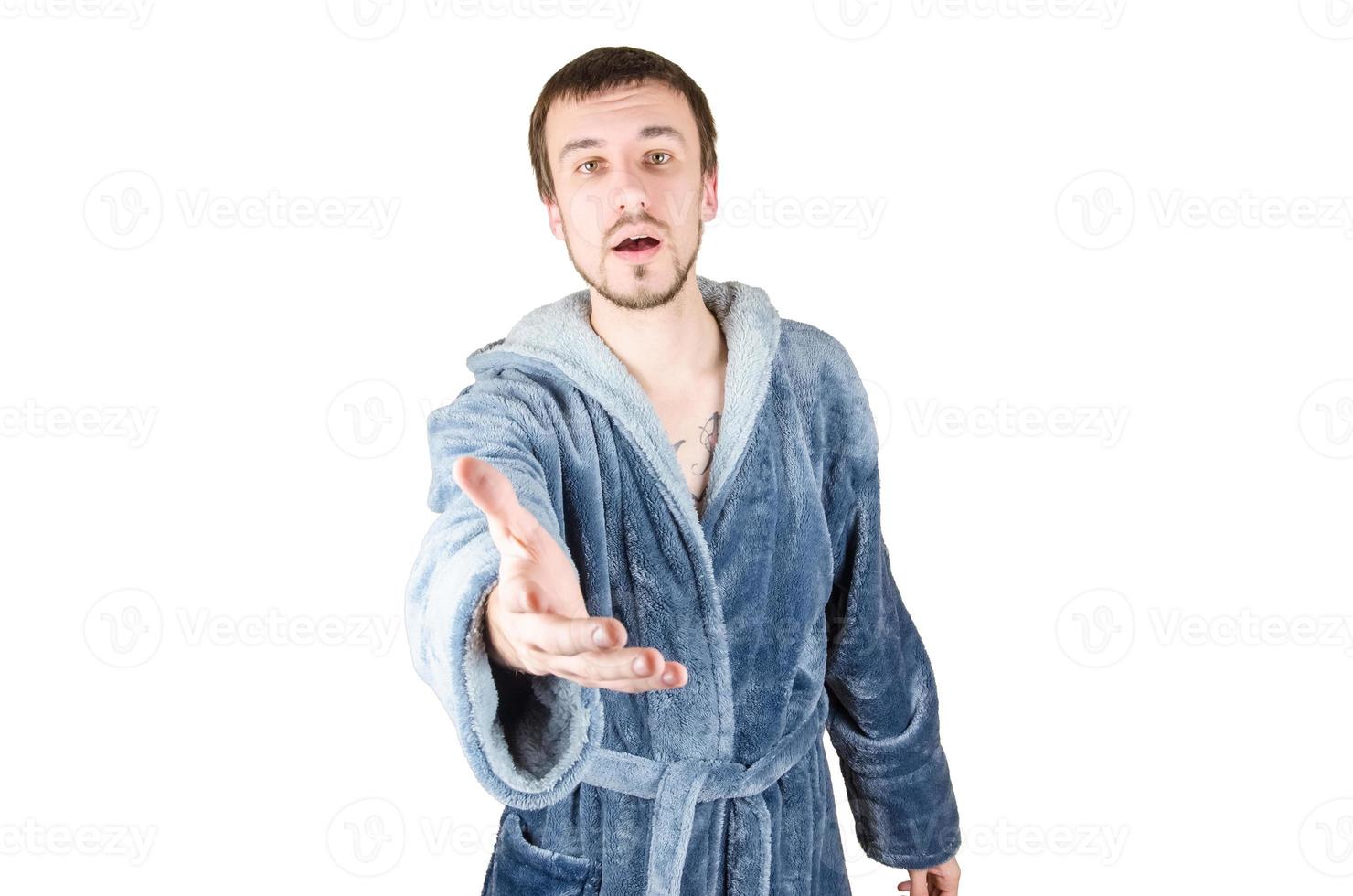 Portrait of young caucasian bearded man in blue bathrobe inviting to come isolated on white background photo