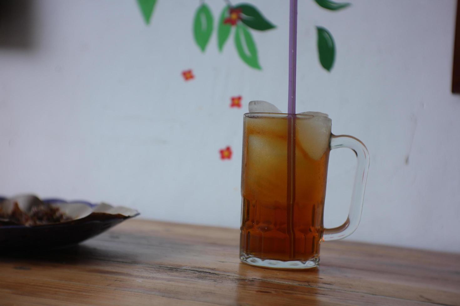 a glass of iced tea on a wooden table photo