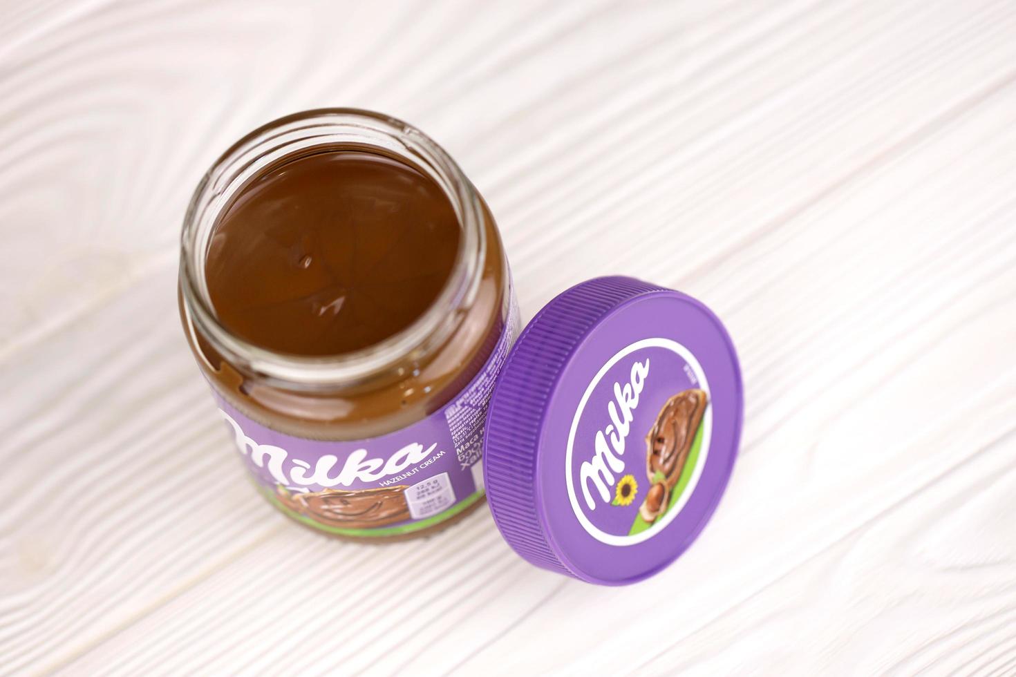 KHARKOV, UKRAINE - JULY 2, 2021 Can of Milka sweetened hazelnut cocoa spread with classical lilac color design on white table photo