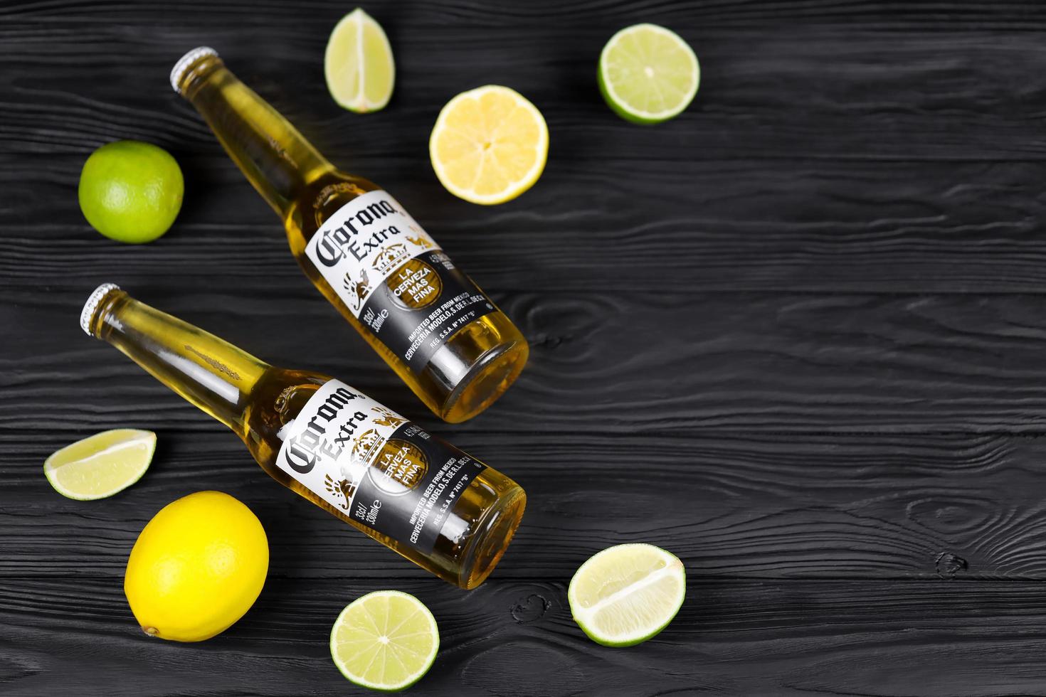 KHARKOV, UKRAINE - DECEMBER 9, 2020 Bottles of Corona Extra Beer with lime slices. Corona produced by Grupo Modelo with Anheuser Busch InBev most popular imported beer in the US photo