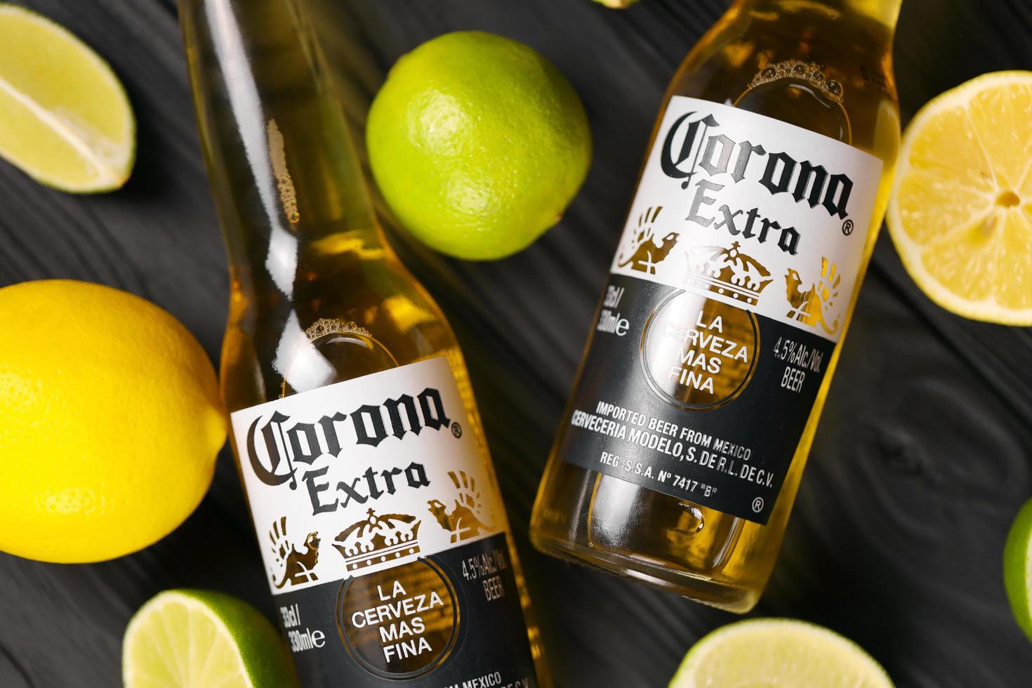 KHARKOV, UKRAINE - DECEMBER 9, 2020 Bottles of Corona Extra Beer with lime slices. Corona produced by Grupo Modelo with Anheuser Busch InBev most popular imported beer in the US photo