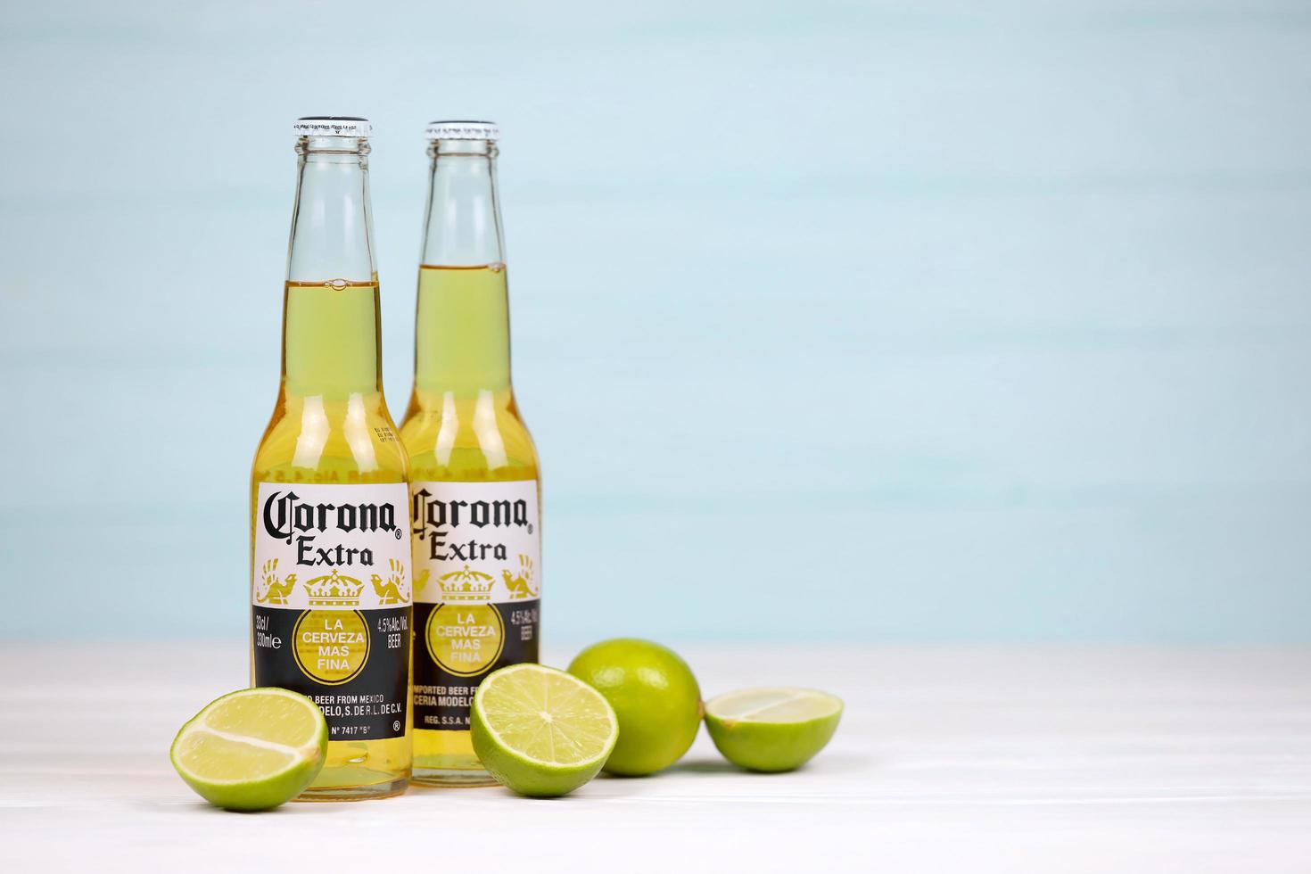 KHARKOV, UKRAINE - DECEMBER 9, 2020 Bottles of Corona Extra Beer with lime slices. Corona produced by Grupo Modelo with Anheuser Busch InBev most popular imported beer in the US photo