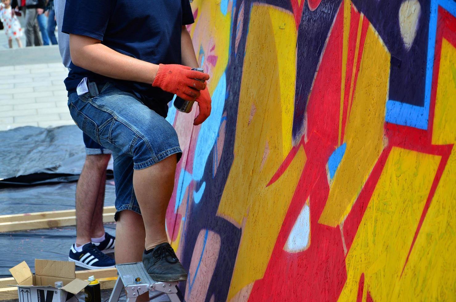 kharkov, ucrania - 27 de mayo de 2017 festival de artes callejeras. jóvenes dibujan graffiti en paredes portátiles de madera en el centro de la ciudad. el proceso de pintar en las paredes con latas de aerosol foto