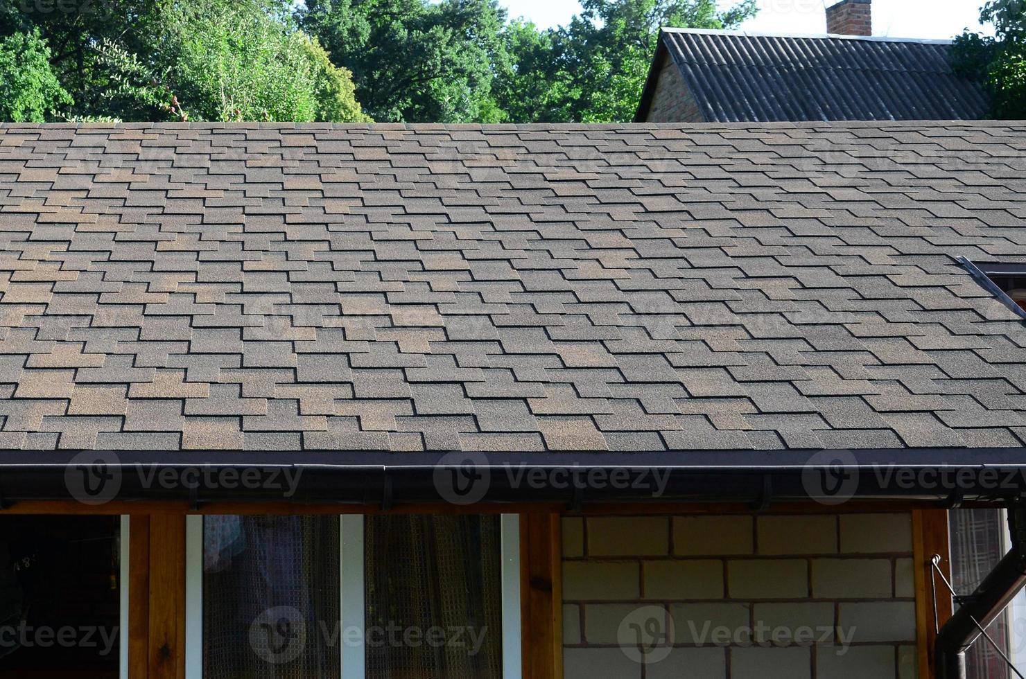 Modern roofing and decoration of chimneys. Flexible bitumen or slate shingles photo