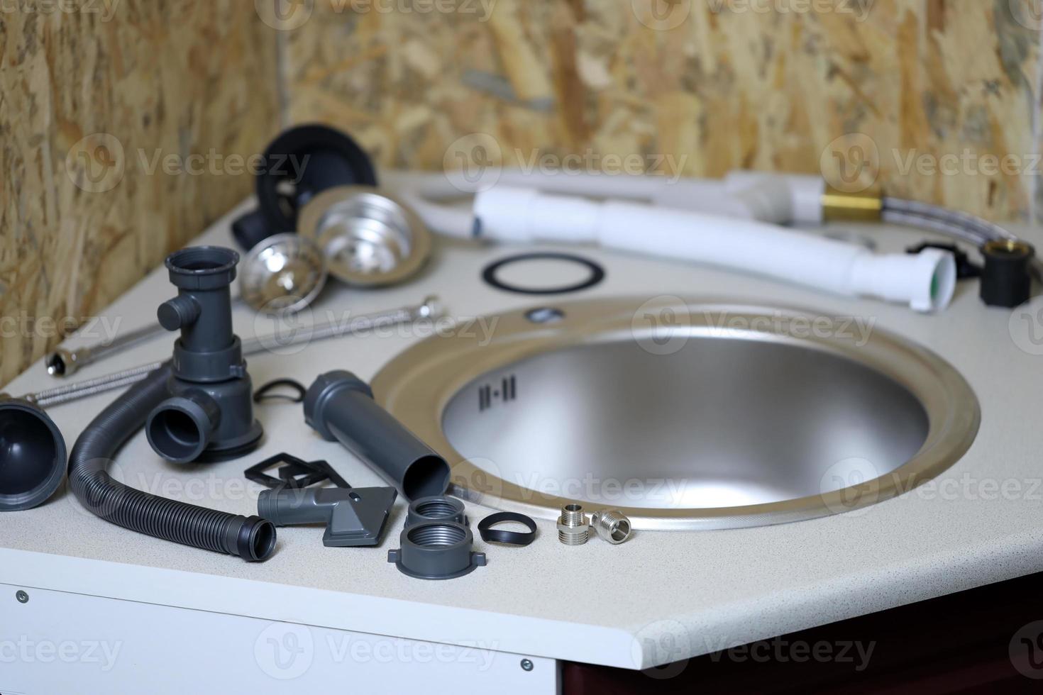 Tools and water tap ready for installation sink on countertop photo