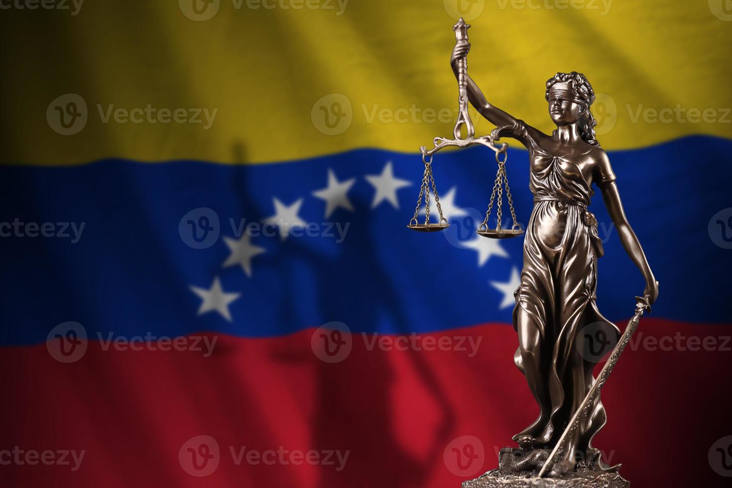 bandera de venezuela con estatua de la dama de la justicia y escalas judiciales en cuarto oscuro. concepto de juicio y castigo foto