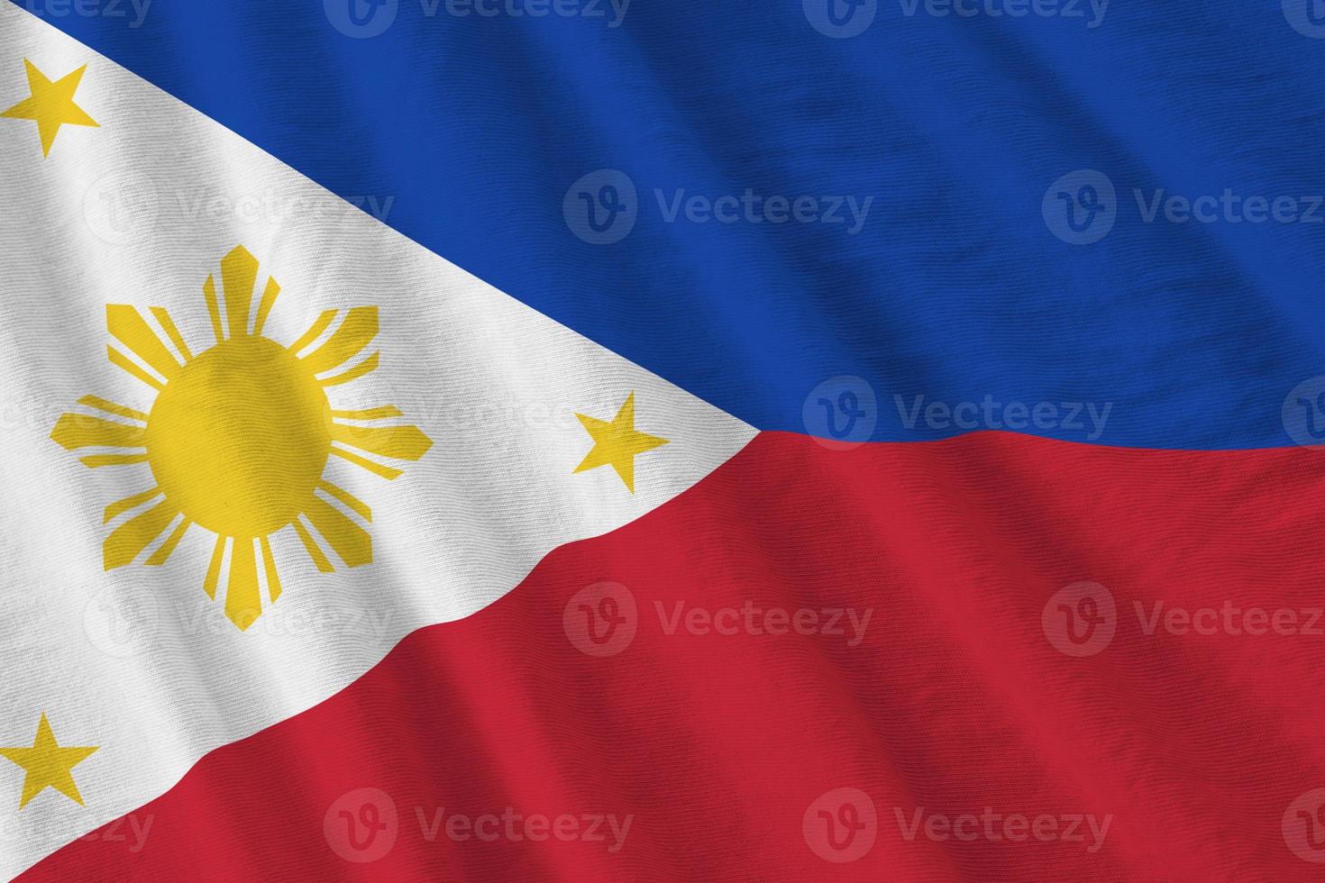 Philippines flag with big folds waving close up under the studio light indoors. The official symbols and colors in banner photo