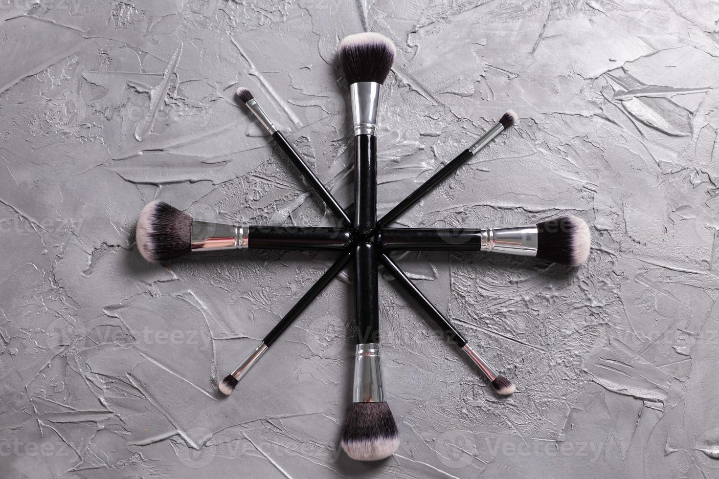 Top view of make-up brushes on grey background photo