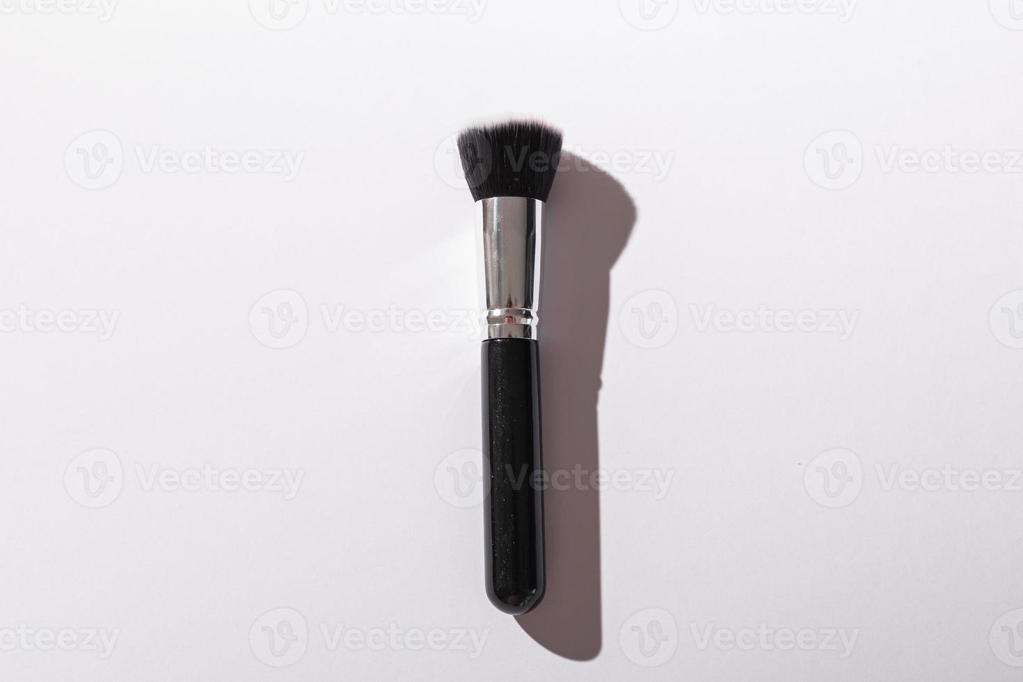 Make-up brush on white background, top view. Cosmetics and beauty concept. photo