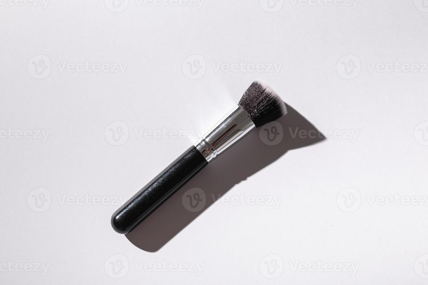 Make-up brush on white background, top view. Cosmetics and beauty concept. photo
