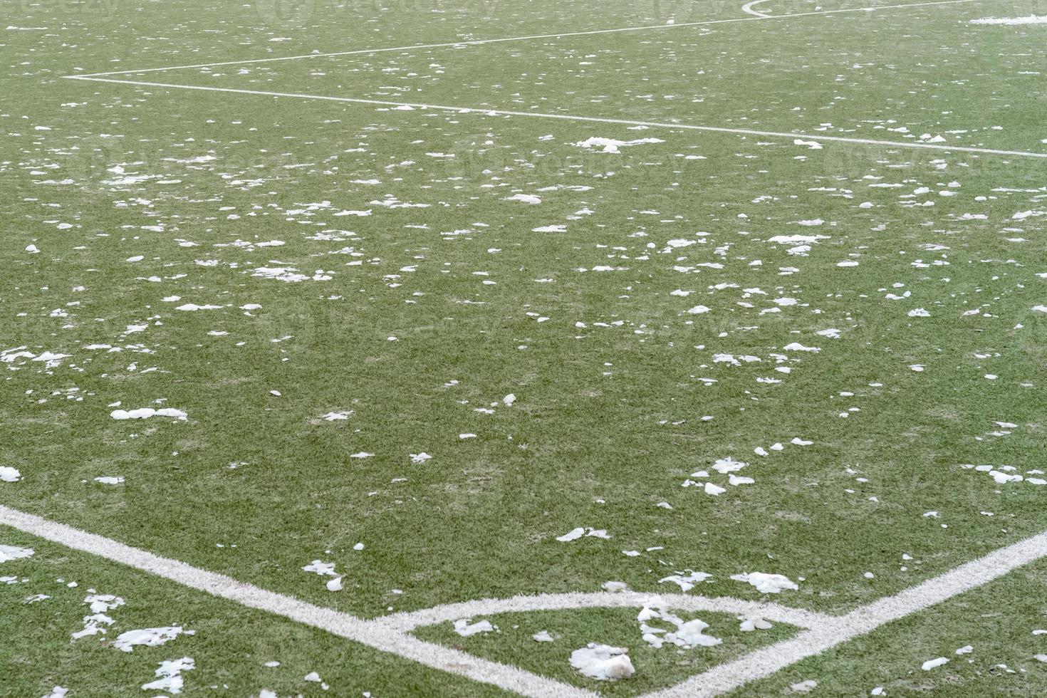 Football pitch with small piles of snow in winter photo