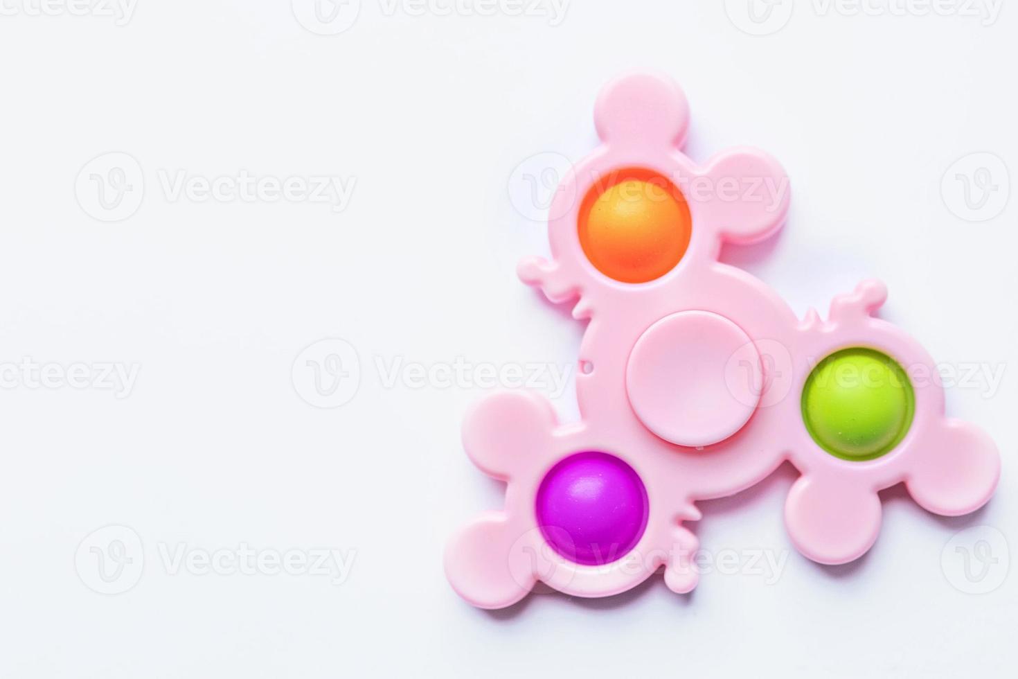 Pop it fidget toy. Multi-colored anti-stress toy with a wing shape on a white background photo