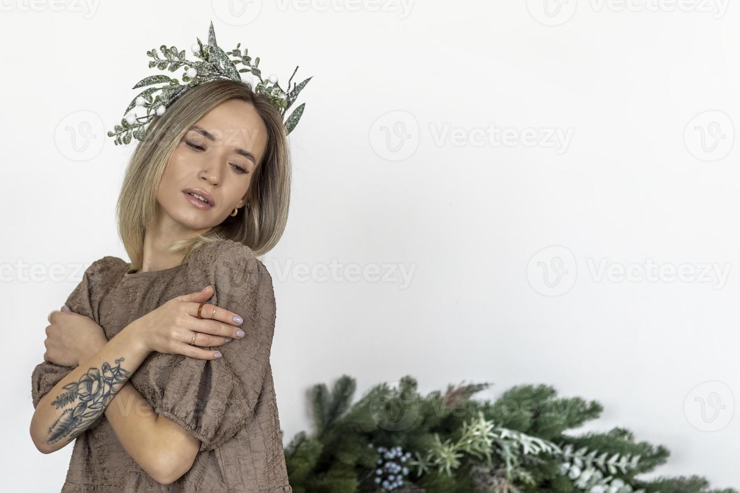 A young woman with blonde hair with a Christmas wreath. New Year's concept,Christmas decorations. photo