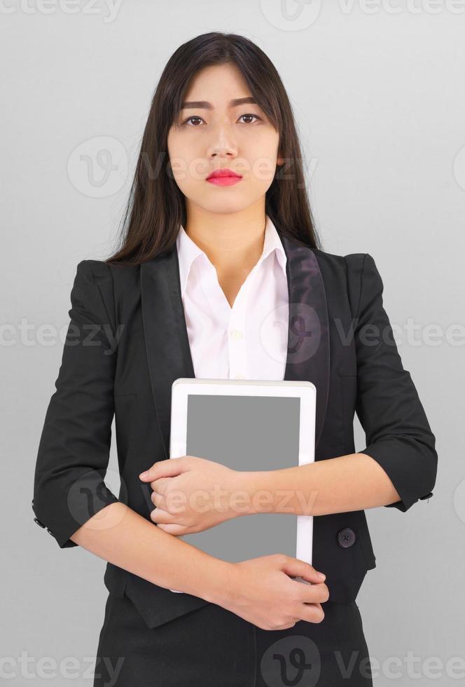 Young women standing in suit holding digital tablet photo