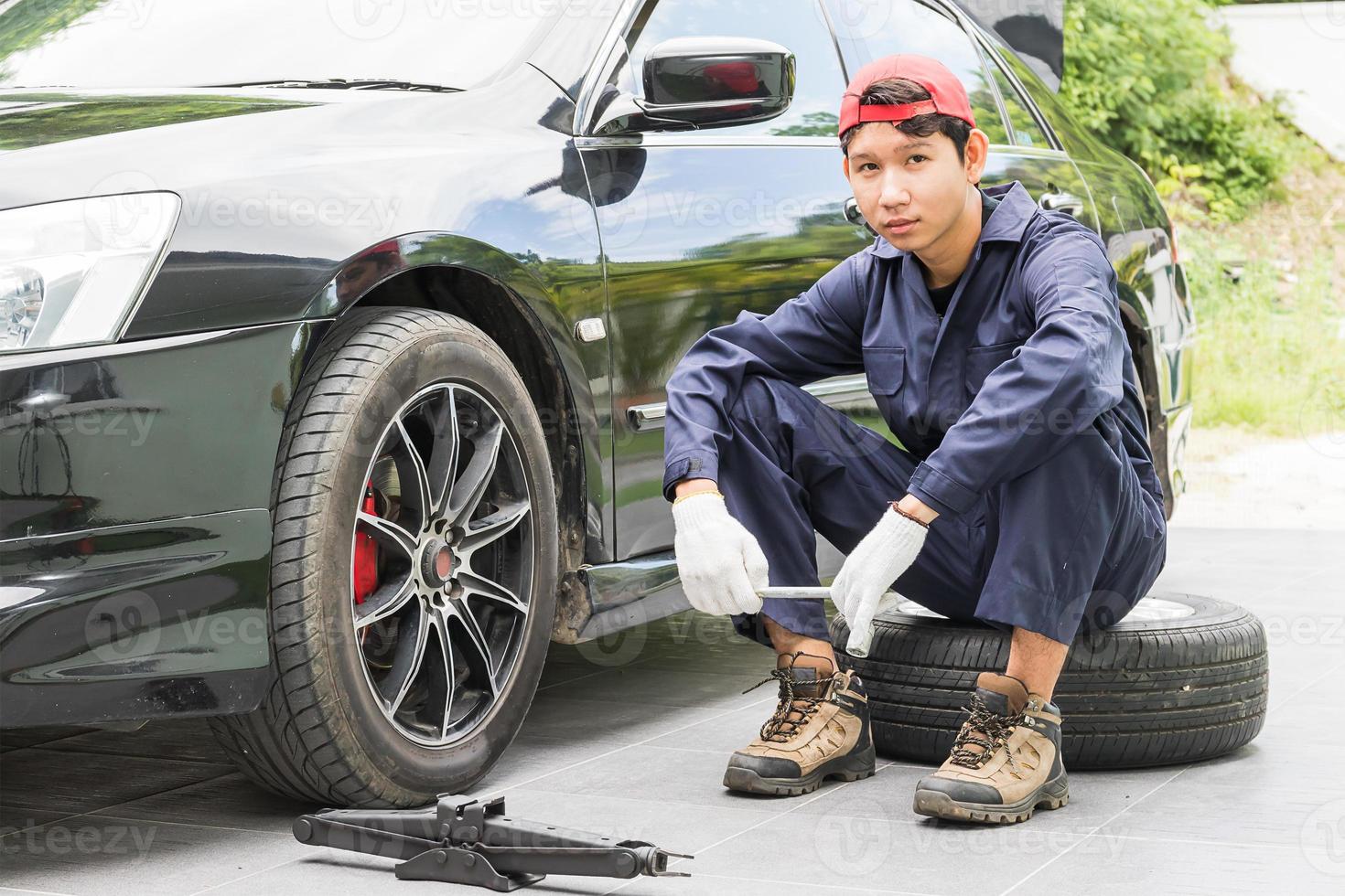 Mechanic replacing lug nuts changing tires on vehicle photo