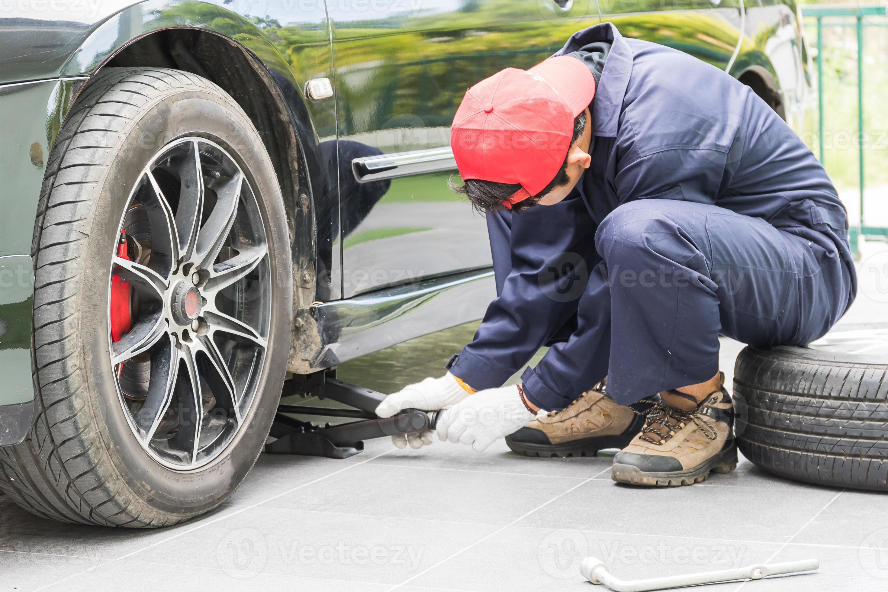 Mechanic replacing lug nuts changing tires on vehicle 15603162 Stock