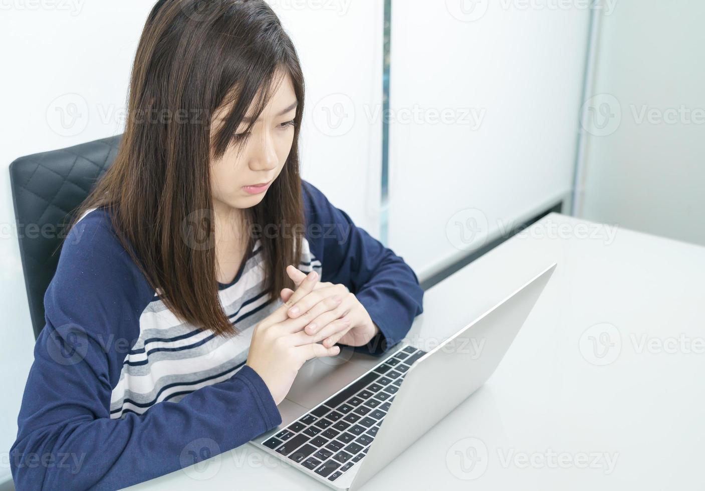 Young female student  sitting in living room and learning online photo