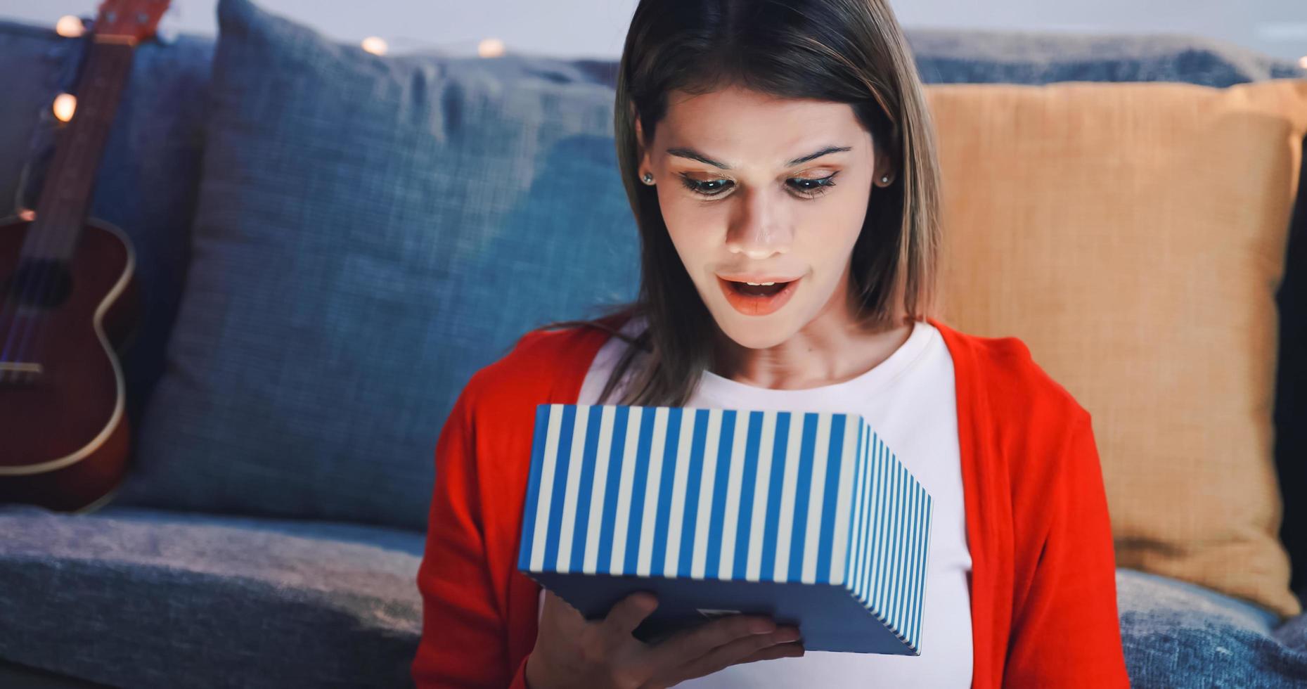 Beautiful young woman is happy to receive a Christmas present from her friend. photo