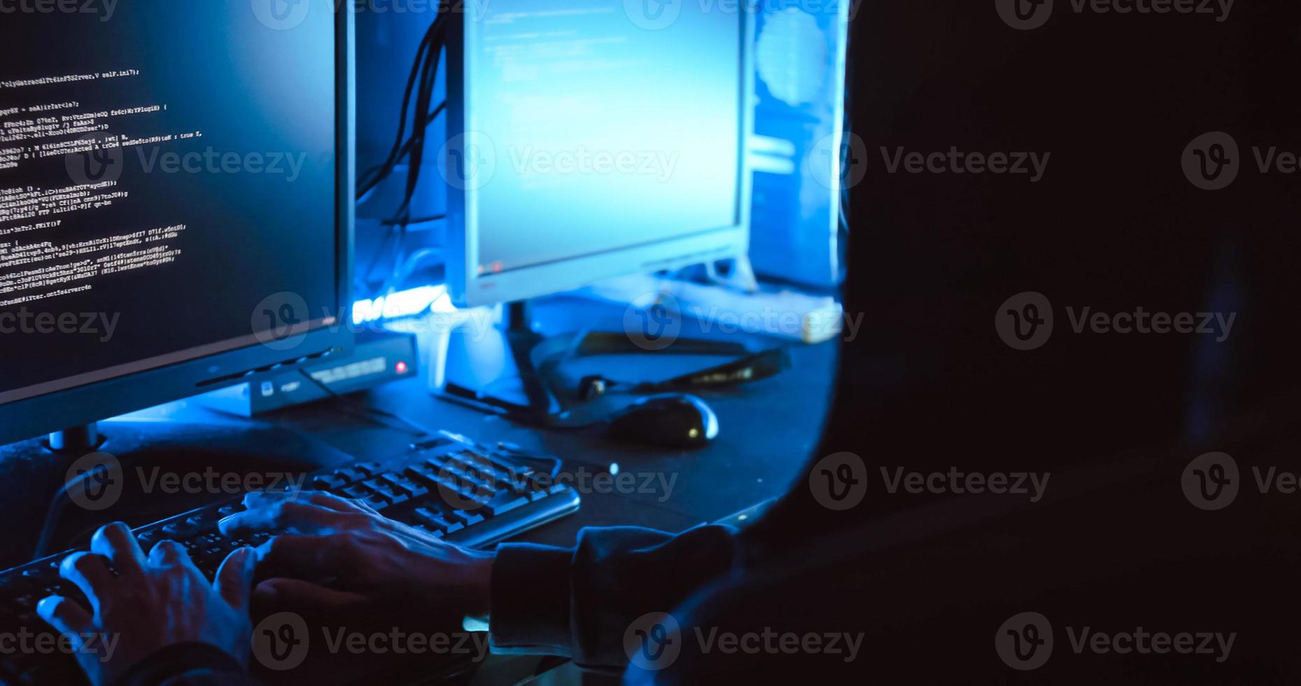A male hacker is using a computer to hack data to demand ransom from victims. photo