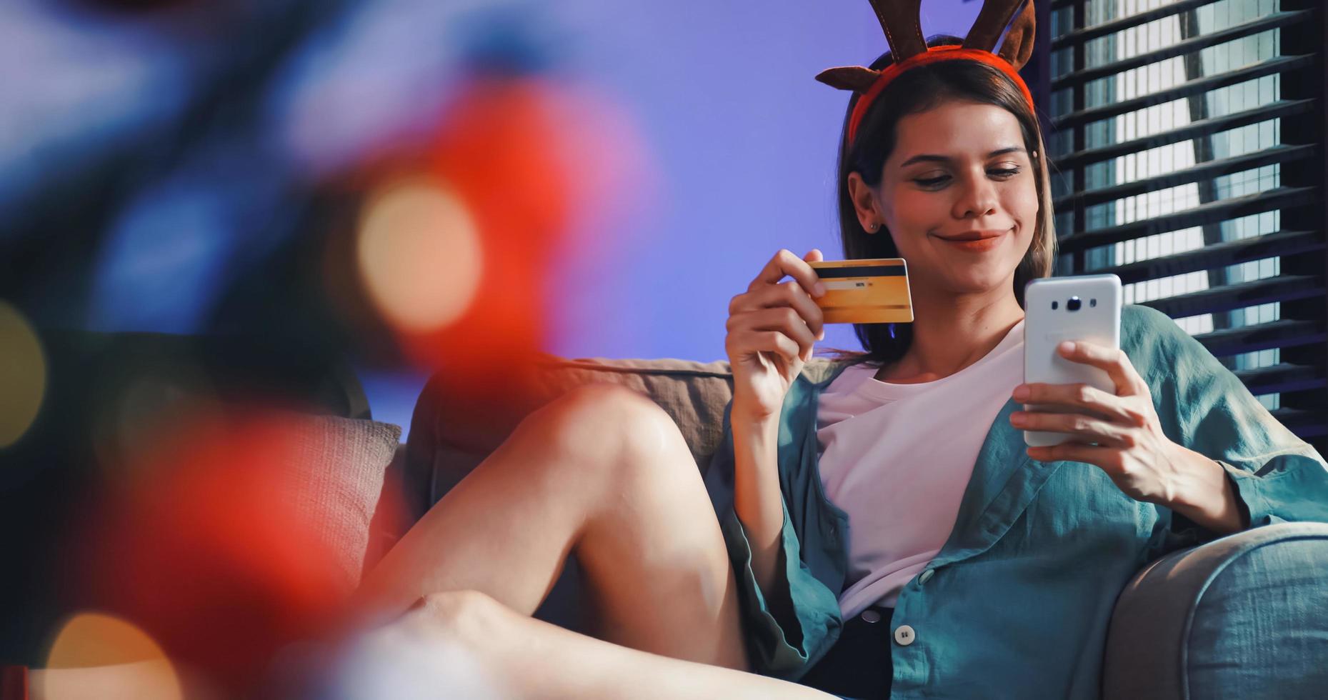 A young woman is shopping online using credit card to buy Christmas gift. photo