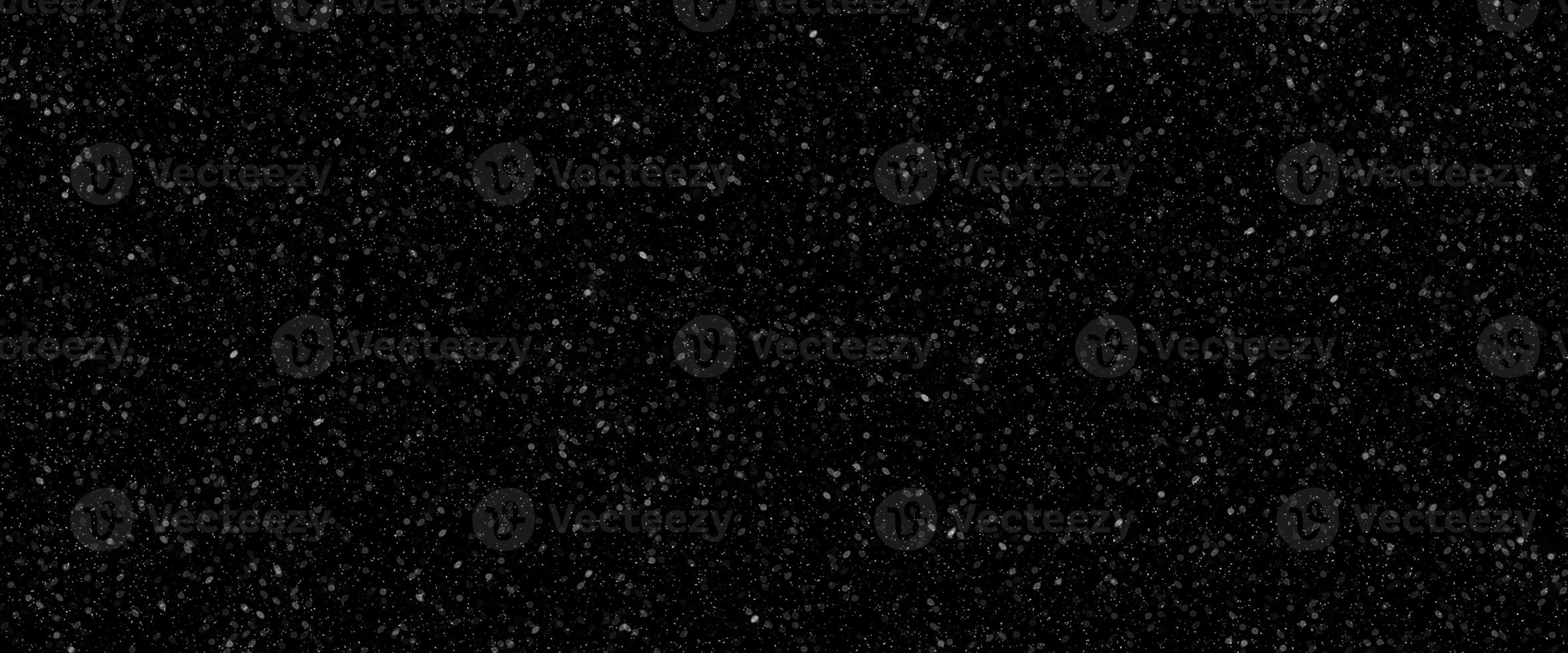 Falling snow flakes, Flying dust particles on a black background. Abstract winter background. Winter landscape with falling shining beautiful snow. photo