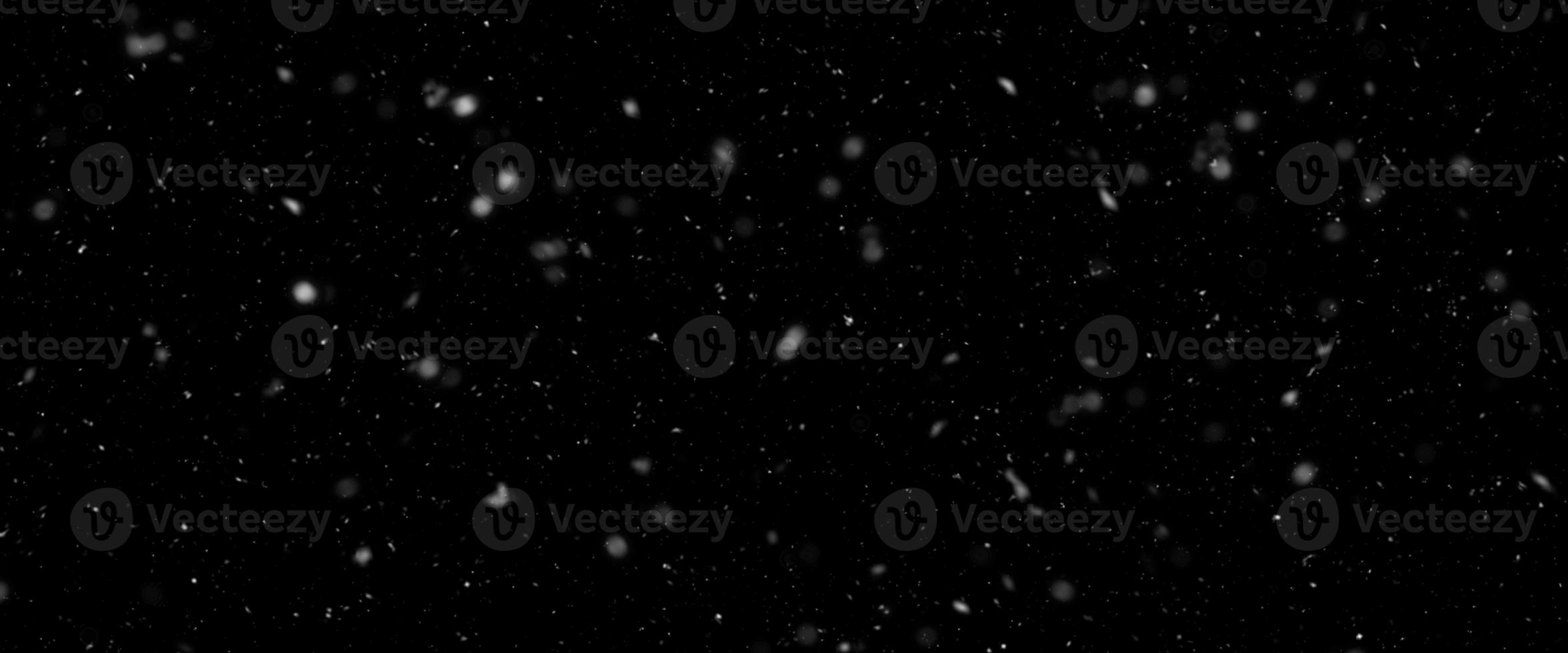 Snowfall bokeh on black background. Many snowflakes in flying in the air. Winte night snowfall and blizzard of snow at. Blur bokeh light effect creative background. photo