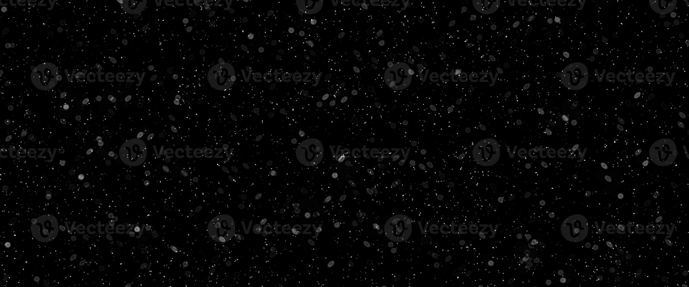 Snowfall bokeh on dark foundation. Numerous snowflakes in flying in the air. Winte night snowfall and snowstorm of snow at. Obscure bokeh light impact innovative foundation. photo