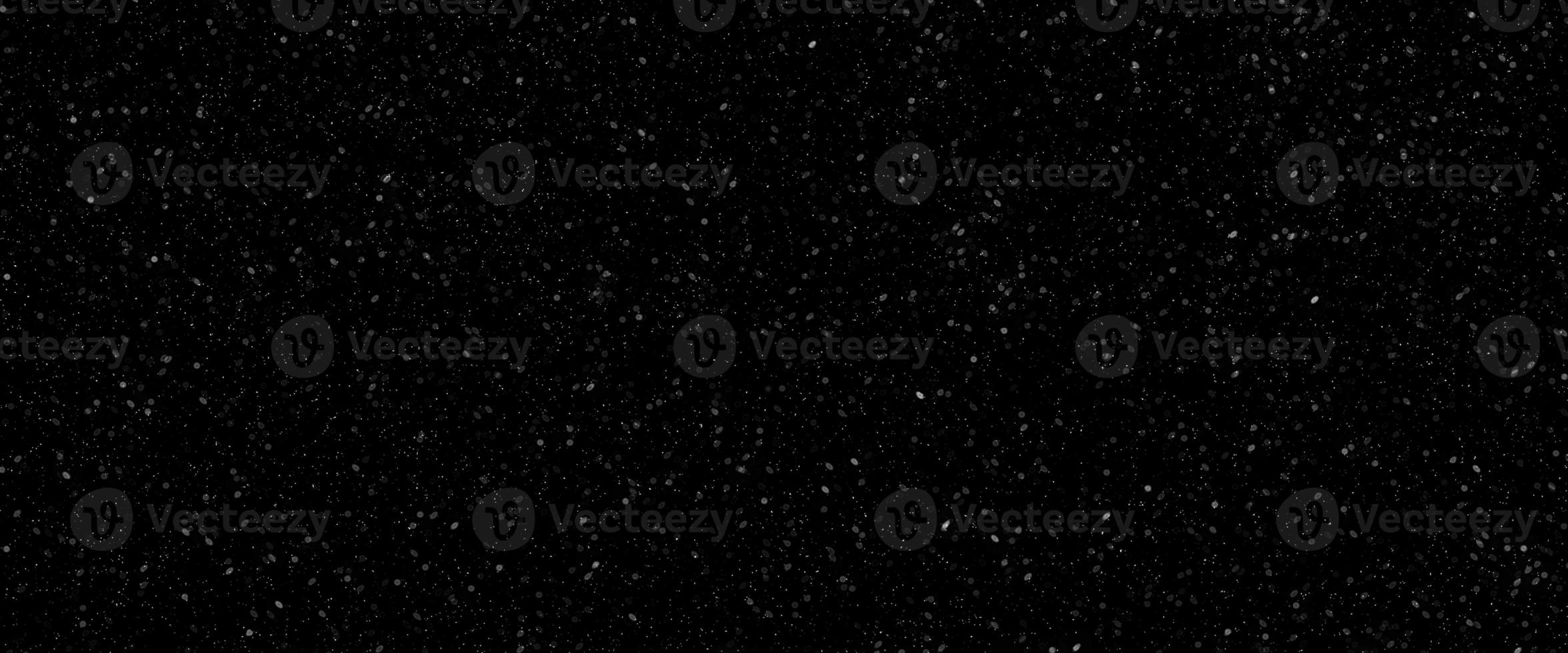 Falling snow flakes, Flying dust particles on a black background. Abstract winter background. Winter landscape with falling shining beautiful snow. photo