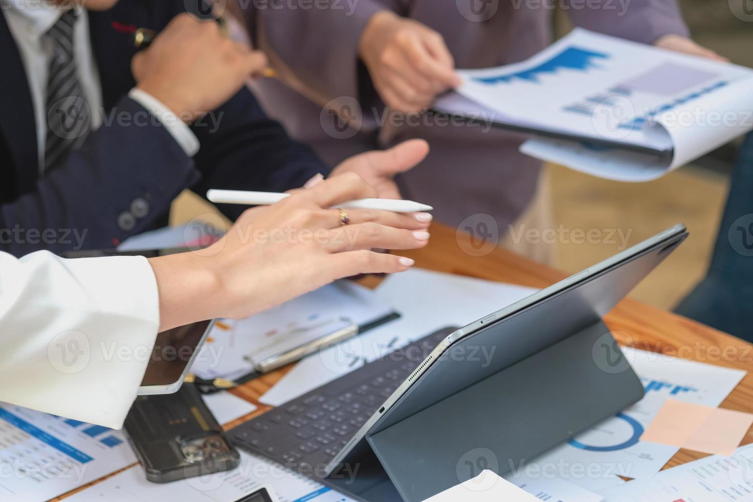 Asian business team consists of marketing staff. accountant and financial officer Help each other analyze company profits using tablets. calculator Laptop computers, graph paper, and corporate pens. photo