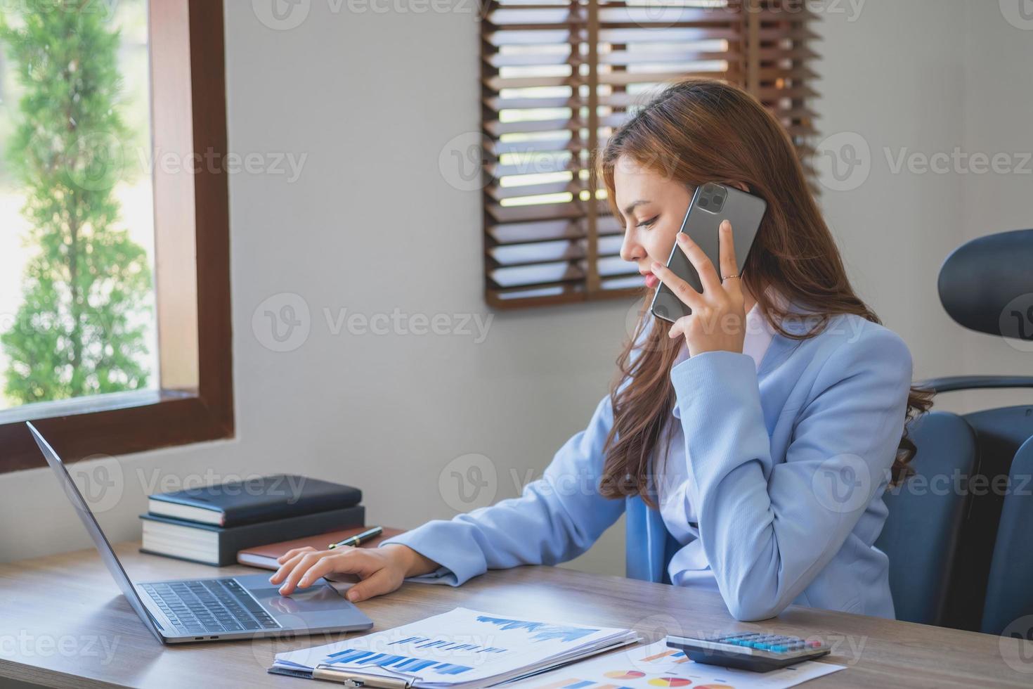 Marketing, Financial, Accounting, Planning, Mixed race business woman uses a mobile phone to contact a customer to inform her of the company's business partnership. Business concept photo