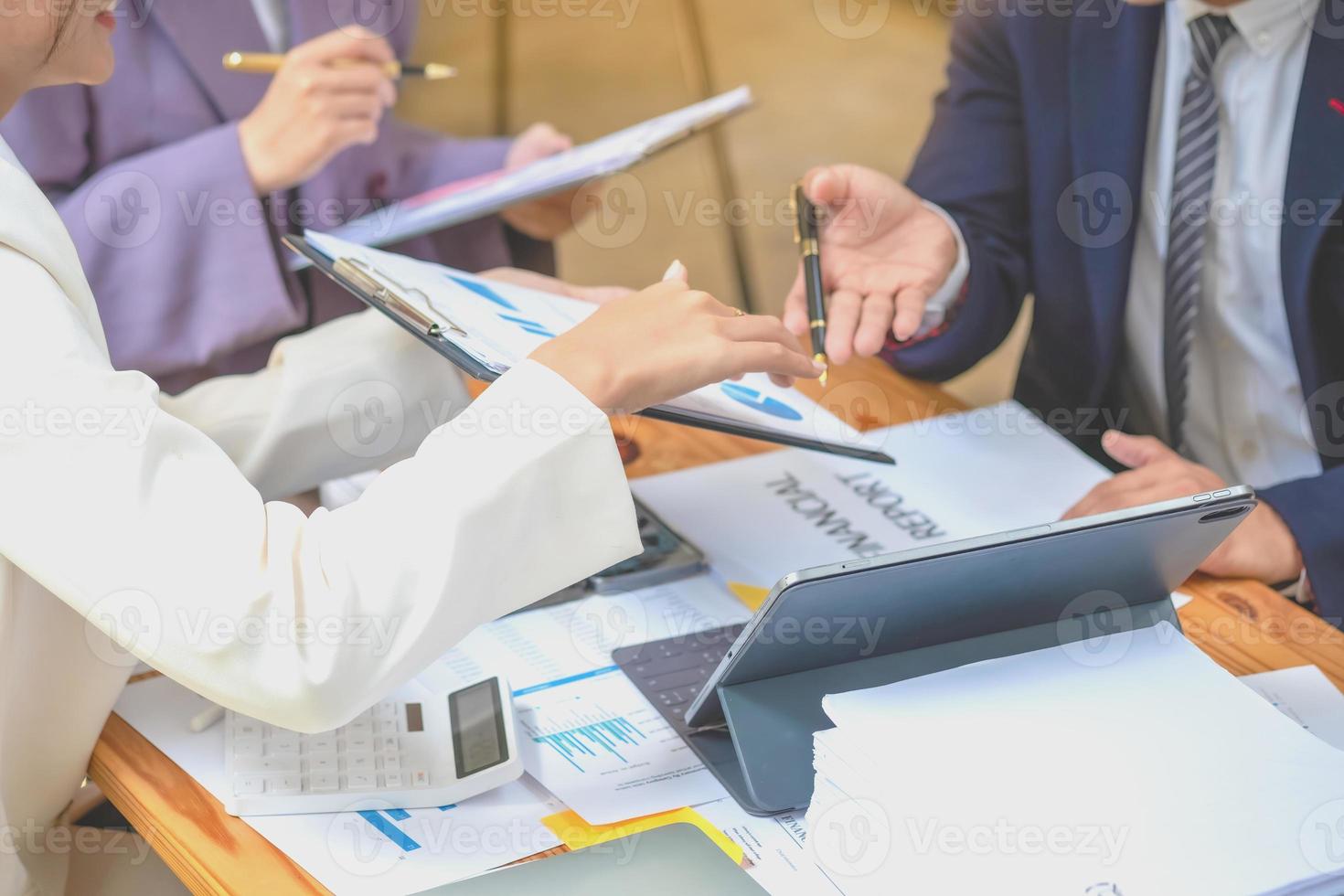 Asian business team consists of marketing staff. accountant and financial officer Help each other analyze company profits using tablets. calculator Laptop computers, graph paper, and corporate pens. photo