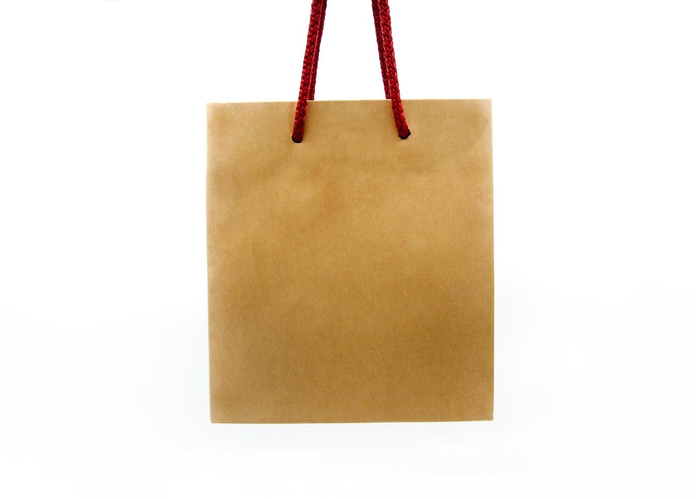 Brown shopping bag with red rope isolated on white background with clipping path or make selection. Paper container, natural material and recycle object. photo
