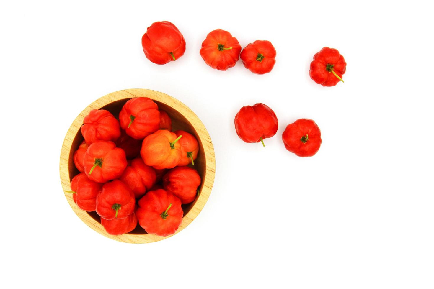 Top view of fresh cherry Acerola, Barbados Cherry, West Indian Cherry or Wild Crapemyrtle in wooden bowl isolated on white background with copy space. Scientific name is Malpighia emarginat. photo