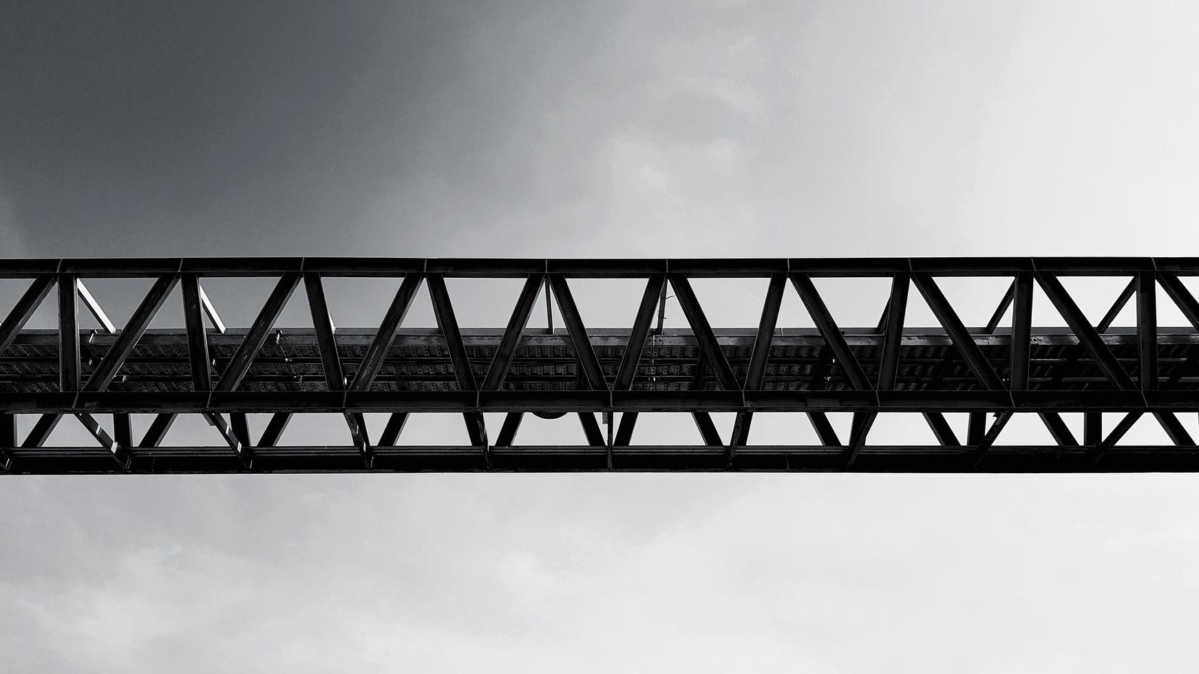 Bottom view of stainless steel electrical or communication cable tray with sky background with copy space in black and white tone. Iron bridge cross to air in monochrome style. photo