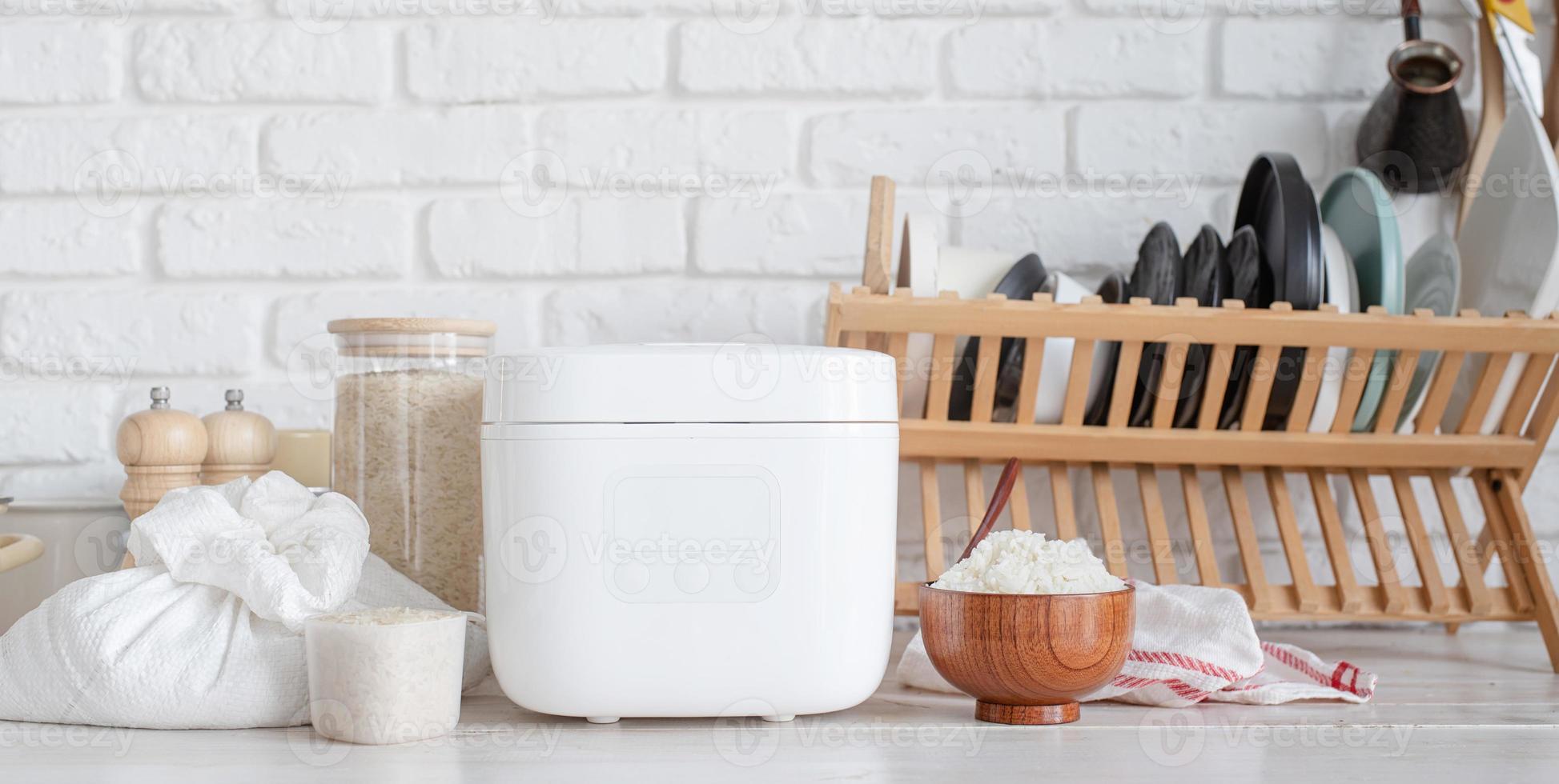 Electric rice cooker on wooden counter-top in the kitchen photo