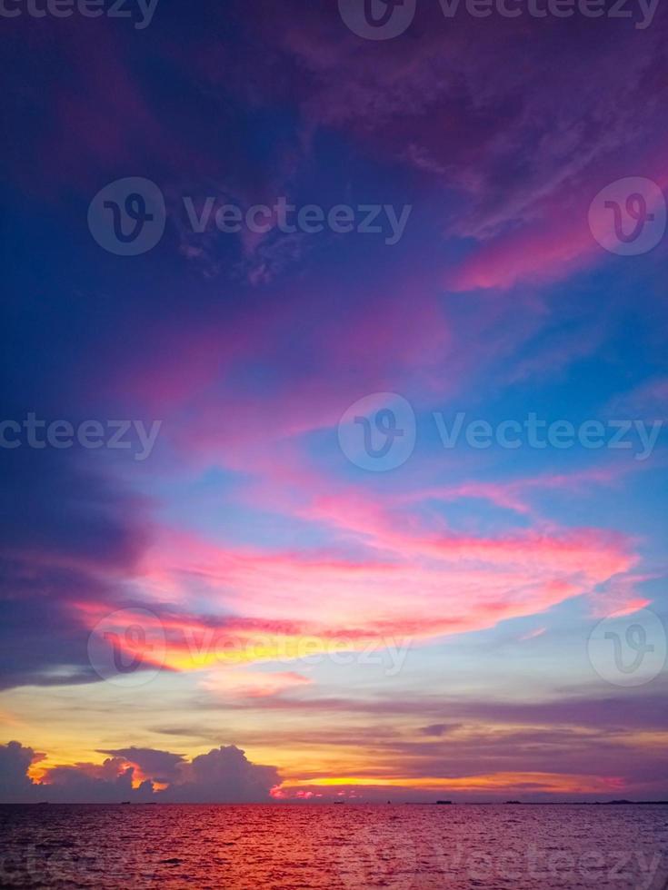 puesta de sol rojo naranja nube púrpura en el cielo azul claro y oscuro foto