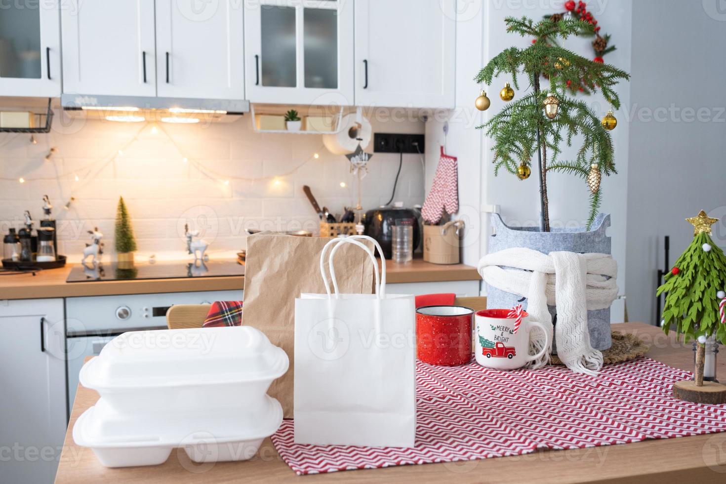 Food delivery service containers on table white scandi festive kitchen in christmas decor. Eve New year, saving time, too lazy to cook, hot order, disposable plastic box in fairy light. mock up photo