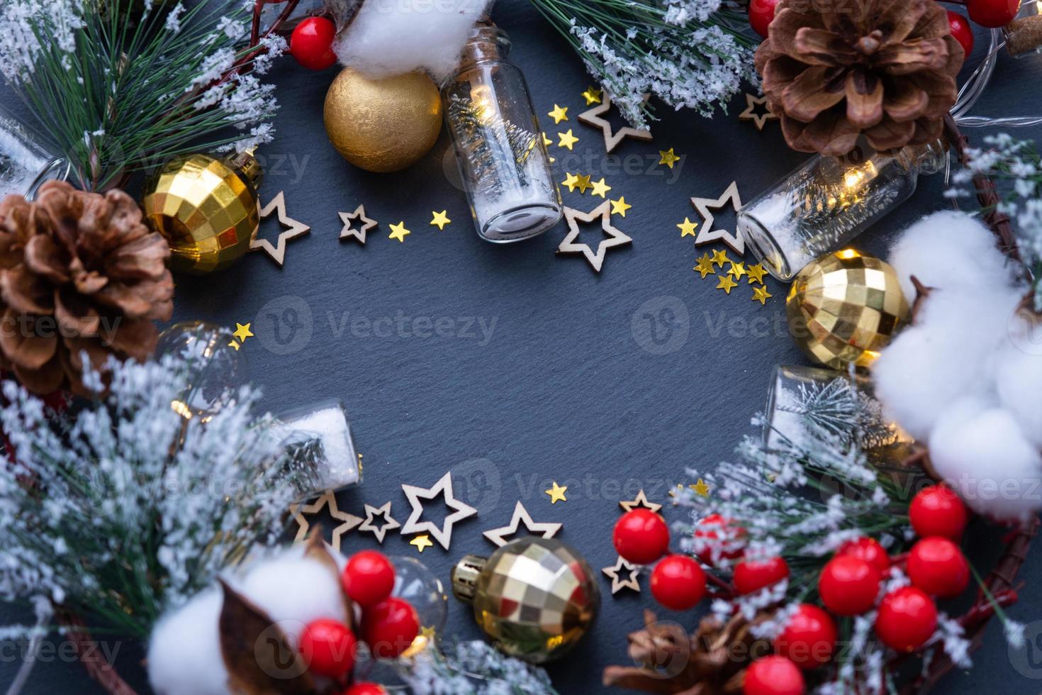 Festive frame with a place for Christmas and New Year's theme text. Sequins, stars, garland, cones, balls on a black stone background of slate. Copyspace, greeting card photo