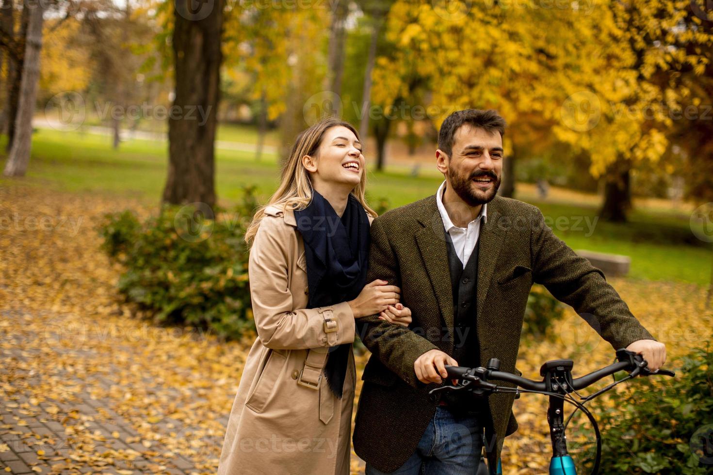 pareja joven, en, el, otoño, parque, con, bicicleta eléctrica foto